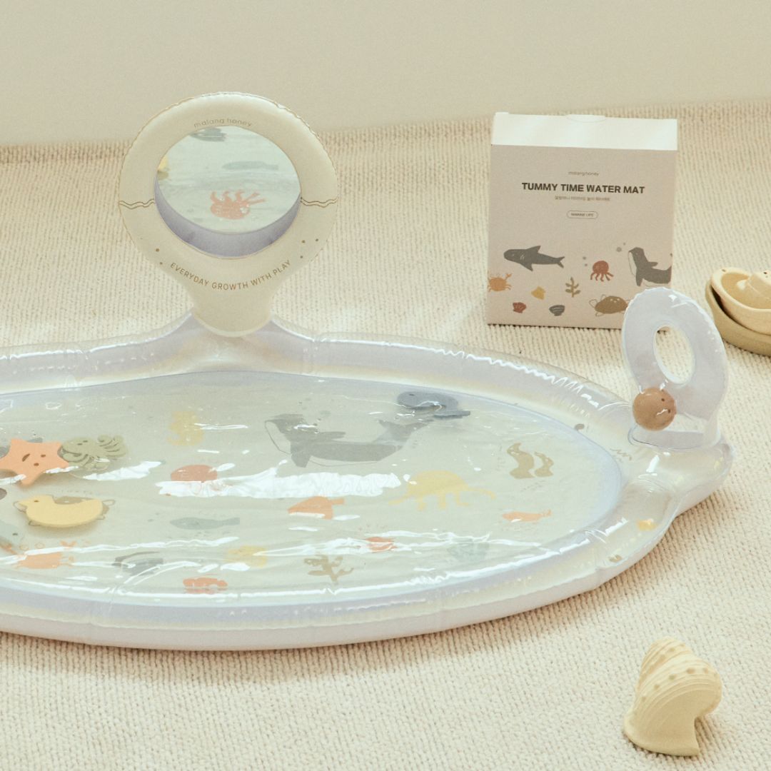 Baby tummy time water mat with toys on a beige surface