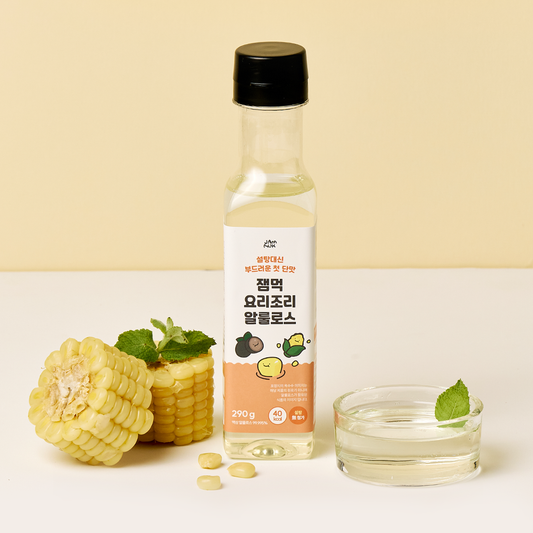 Bottle of allulose natural sweetener with corn and a glass on a light background